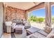 Cozy covered patio with a stone fireplace, comfortable seating, and curtains at 2383 E Zion Way, Chandler, AZ 85249