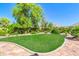 Landscaped backyard features lush green grass, mature trees, and stone patio, creating a private outdoor oasis at 2383 E Zion Way, Chandler, AZ 85249