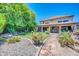 Beautiful backyard with lush landscaping, stone pathway, and a charming two-story home at 2383 E Zion Way, Chandler, AZ 85249