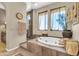 This bathroom features a soaking tub, elegant window treatments, and tile surround at 2383 E Zion Way, Chandler, AZ 85249