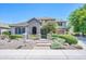 Charming two-story home features a stone archway, lush landscaping, and a welcoming entryway at 2383 E Zion Way, Chandler, AZ 85249