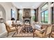 Comfortable living room featuring a stone fireplace, decorative rug, comfortable seating, and ample natural light at 2383 E Zion Way, Chandler, AZ 85249