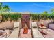 Inviting patio space with sun loungers, decorative plants, and a carved wooden gate at 2383 E Zion Way, Chandler, AZ 85249
