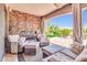 Inviting covered patio with a fireplace, comfortable seating, and views of the landscaped yard at 2383 E Zion Way, Chandler, AZ 85249