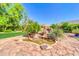Rock water feature surrounded by manicured landscaping with lush green trees at 2383 E Zion Way, Chandler, AZ 85249