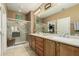 Bathroom with double sinks, a glass enclosed shower, and a door to the walk-in closet at 27244 W Potter Dr, Buckeye, AZ 85396
