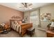 Bedroom featuring a decorative headboard, a large window, and a rocking chair at 27244 W Potter Dr, Buckeye, AZ 85396