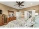 Bedroom features a ceiling fan, wood dresser, and views to the bathroom and closet at 27244 W Potter Dr, Buckeye, AZ 85396