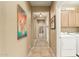 Hallway leading to the laundry room and bathroom featuring tile flooring and neutral colored walls at 27244 W Potter Dr, Buckeye, AZ 85396
