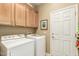 Laundry room with tile floors, storage cabinets above the white washer and dryer at 27244 W Potter Dr, Buckeye, AZ 85396