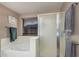 Bathroom featuring a bathtub, glass-enclosed shower, and towel racks at 2748 E Dennisport Ave, Gilbert, AZ 85295
