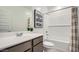 Bathroom with single vanity, artwork, and shower and tub combo at 32693 N Jasper St, San Tan Valley, AZ 85143