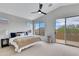 Bright primary bedroom featuring a ceiling fan, a large window, and a sliding glass door to a balcony at 3624 N Paseo Del Sol --, Mesa, AZ 85207