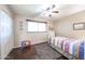 Cozy bedroom showcasing a window, closet, wood floors, and a colorful quilt on the bed at 3633 W Redfield Rd, Phoenix, AZ 85053