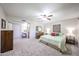 Spacious bedroom showcases neutral carpet, a ceiling fan, and a vanity area with access to the bathroom at 3633 W Redfield Rd, Phoenix, AZ 85053