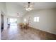 Open dining room with vaulted ceilings, two ceiling fans, and sliding glass doors to the backyard, ideal for Gathering meals at 3633 W Redfield Rd, Phoenix, AZ 85053