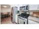Close up of modern kitchen appliances, including a stainless steel refrigerator and gas range at 3633 W Redfield Rd, Phoenix, AZ 85053