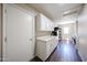 Bright laundry room with white cabinets, countertops, and appliances, plus wood-look tile flooring at 3633 W Redfield Rd, Phoenix, AZ 85053