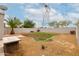 Backyard featuring gravel, large palm tree, privacy wall and large grassy area at 41678 N Salix Dr, San Tan Valley, AZ 85140
