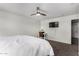 This bright bedroom has a ceiling fan, television, desk, and carpeted flooring at 41678 N Salix Dr, San Tan Valley, AZ 85140