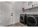 Laundry room with washer and dryer, white door, shelf and laminate flooring at 41678 N Salix Dr, San Tan Valley, AZ 85140