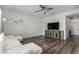 Bright living room featuring a modern ceiling fan, a large tv, and wood-look flooring at 41678 N Salix Dr, San Tan Valley, AZ 85140