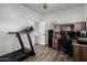 Office with wood laminate flooring, a black office chair, desk, cabinets and treadmill at 41678 N Salix Dr, San Tan Valley, AZ 85140