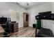 Office with wood laminate flooring, desk, chair, bookcase, treadmill and small window at 41678 N Salix Dr, San Tan Valley, AZ 85140