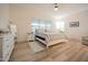 A bright bedroom with a queen bed, nightstands, dresser, ceiling fan and a window at 4571 N Arbor Way, Buckeye, AZ 85396
