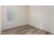 A bright bedroom featuring wood-look flooring and a large window at 4571 N Arbor Way, Buckeye, AZ 85396