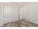 An empty room with hard floors features white walls, doors and a closet at 4571 N Arbor Way, Buckeye, AZ 85396