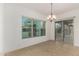 A simple dining room showcasing natural light from a large window, tile floors and sliding glass door at 4571 N Arbor Way, Buckeye, AZ 85396