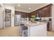 Well-equipped kitchen with dark wood cabinets, island and stainless steel appliances at 4571 N Arbor Way, Buckeye, AZ 85396