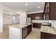 A spacious kitchen with stainless steel appliances, granite countertops and dark wood cabinetry at 4571 N Arbor Way, Buckeye, AZ 85396