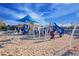 Community playground with a variety of play structures, shade coverings, and a soft wood chip surface at 4571 N Arbor Way, Buckeye, AZ 85396