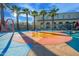 Splash pad next to a community pool features colorful flooring, fountains, and nearby lounge chairs at 4571 N Arbor Way, Buckeye, AZ 85396