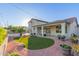 Spacious backyard featuring an artificial lawn area, landscaping, and an inviting covered patio, enhanced by string lights at 47 W Calle Monte Vis, Tempe, AZ 85284