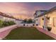 Spacious backyard featuring a well-maintained lawn area, landscaping, and an outdoor basketball court, enhanced by string lights at 47 W Calle Monte Vis, Tempe, AZ 85284