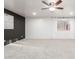 Carpeted living room with ceiling fan, painted accent wall, and ample natural light at 47 W Calle Monte Vis, Tempe, AZ 85284