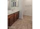 Bathroom with double sink vanity with wood cabinets and neutral colored tile floors at 4730 N 111Th Ln, Phoenix, AZ 85037