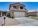 Charming two-story home featuring a tile roof, a two-car garage, and a well-maintained front yard with lovely flowers at 4948 W Wikieup Ln, Glendale, AZ 85308