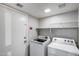 Well-lit laundry room equipped with modern washer and dryer, and functional wire shelving at 4948 W Wikieup Ln, Glendale, AZ 85308