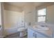 Bright bathroom featuring a white tub, toilet, and sink vanity with natural light at 537 W Kingman Dr, Casa Grande, AZ 85122