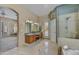 Bright bathroom featuring double sinks, separate shower, bathtub, and private backyard access at 7418 E Black Rock Rd, Scottsdale, AZ 85255