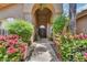 Inviting front entrance with double doors, arched entryway, and colorful landscaping in a desert climate at 7418 E Black Rock Rd, Scottsdale, AZ 85255