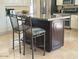 Kitchen island with granite countertop, barstool seating, and dark wood cabinetry at 7418 E Black Rock Rd, Scottsdale, AZ 85255