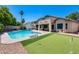 Inviting backyard with a sparkling pool, putting green, and an adjacent patio area perfect for outdoor relaxation at 7435 W Trails Dr, Glendale, AZ 85308
