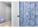 Close-up of a bathroom with a seashell-patterned shower curtain and white door providing detail at 7435 W Trails Dr, Glendale, AZ 85308