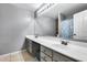 Bathroom featuring double sinks, a large mirror with vanity lights, and a bathtub-shower combination at 7435 W Trails Dr, Glendale, AZ 85308