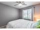 A bedroom features a gray wall color, carpet flooring, curtains, a ceiling fan, and a queen-sized bed at 7435 W Trails Dr, Glendale, AZ 85308